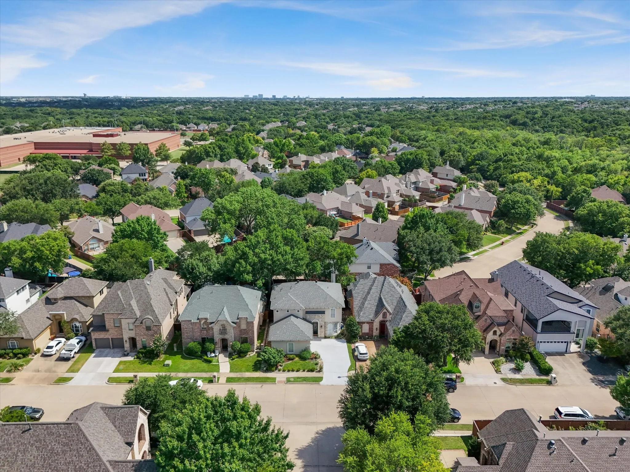 Aerial perspective of a residential neighborhood with tree-lined streets and varied architectural styles