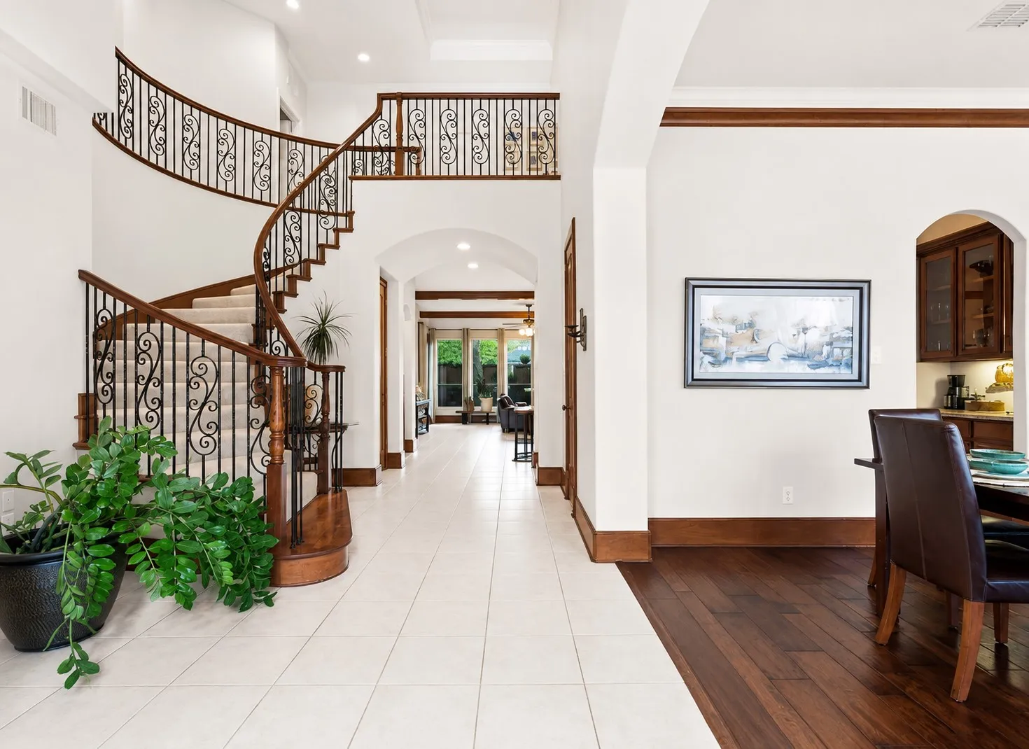 Beautiful curved staircase with ornate wrought iron balusters