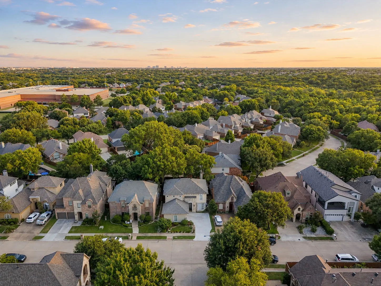 Expansive residential area with numerous single-family homes, mature trees, and paved streets
