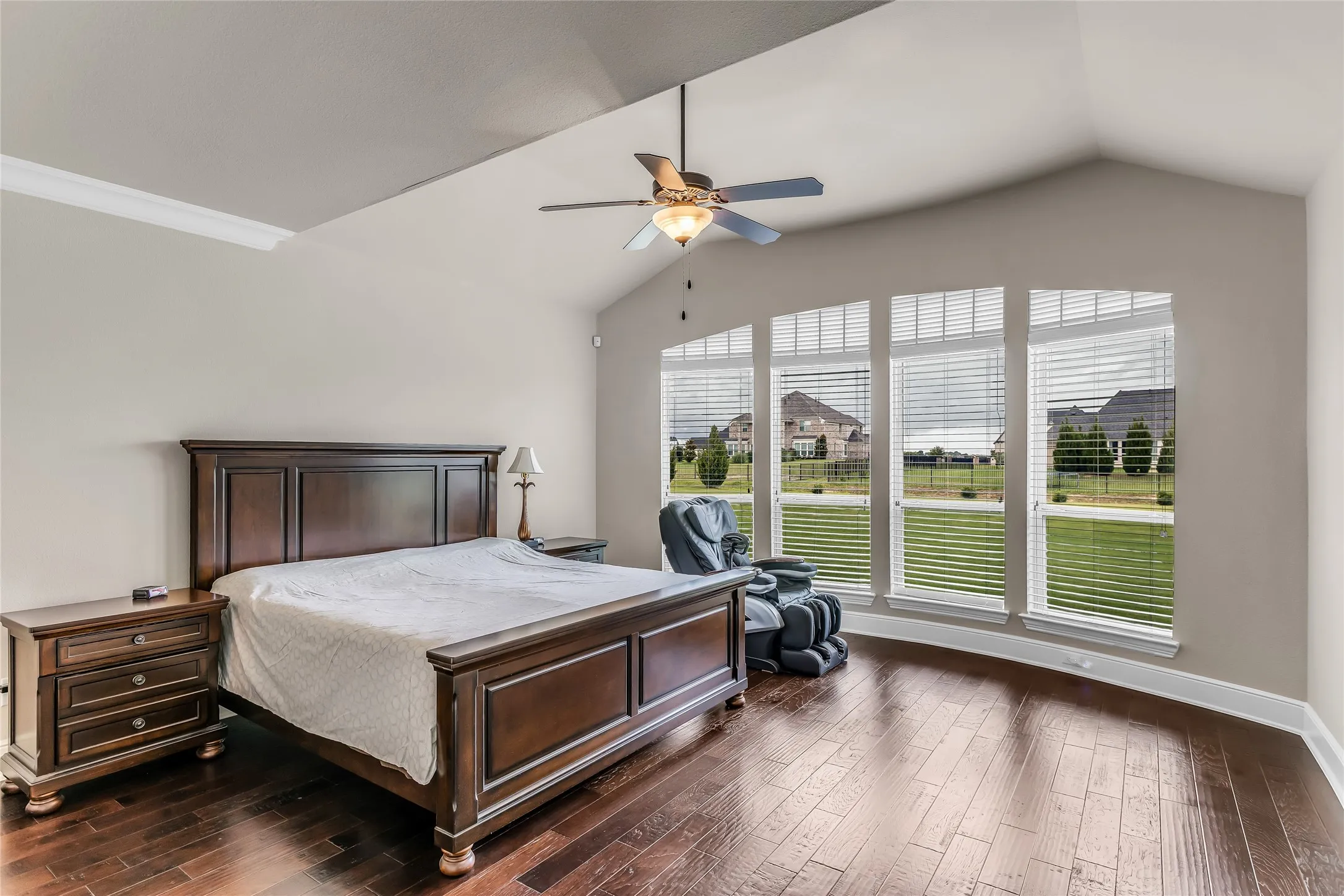 Vaulted ceiling bedroom with wood-finish flooring