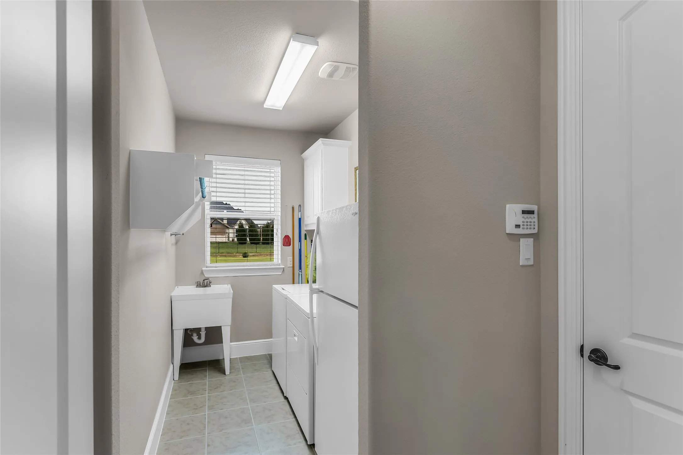 Dedicated laundry room with sink and room for second fridge