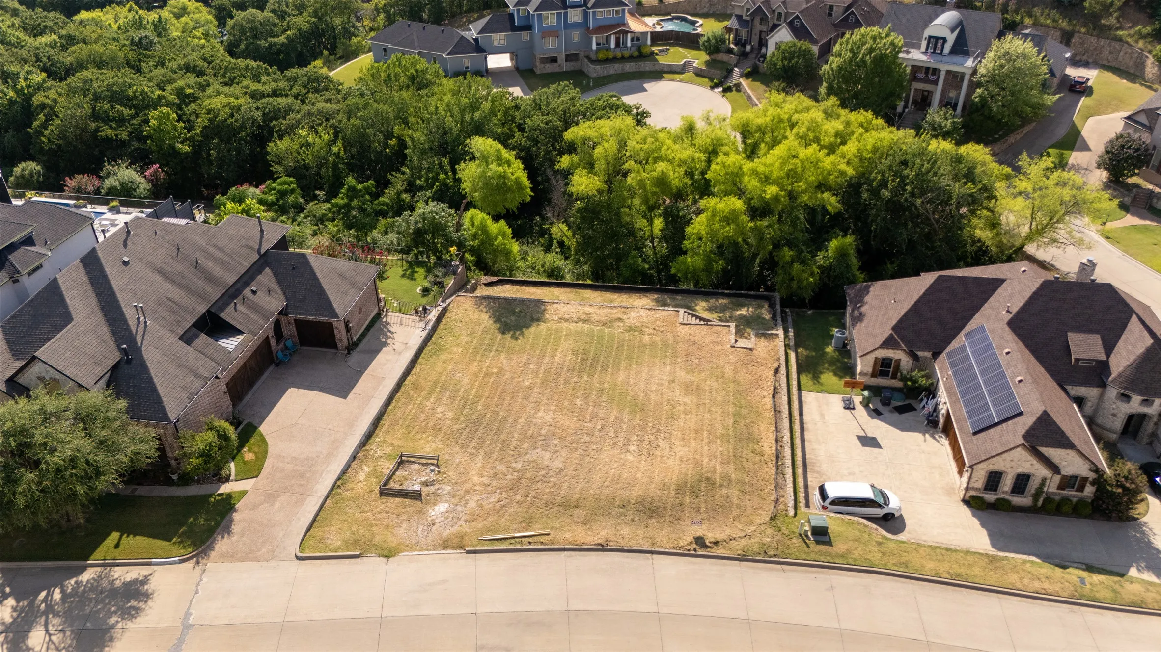 Expansive lot with established surrounding properties, retaining wall, and street access