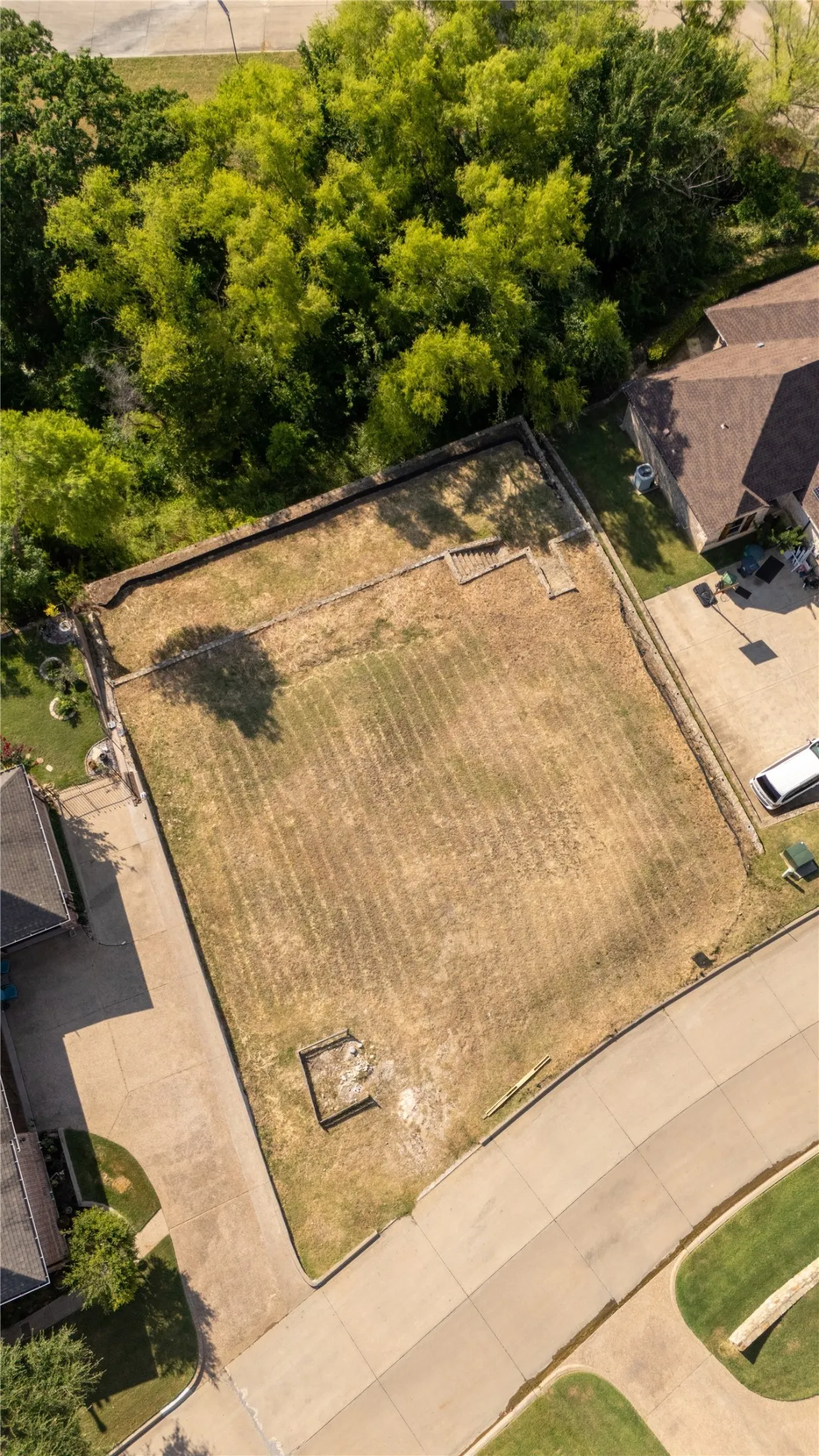 Expansive building lot featuring established boundary fencing and mature perimeter trees