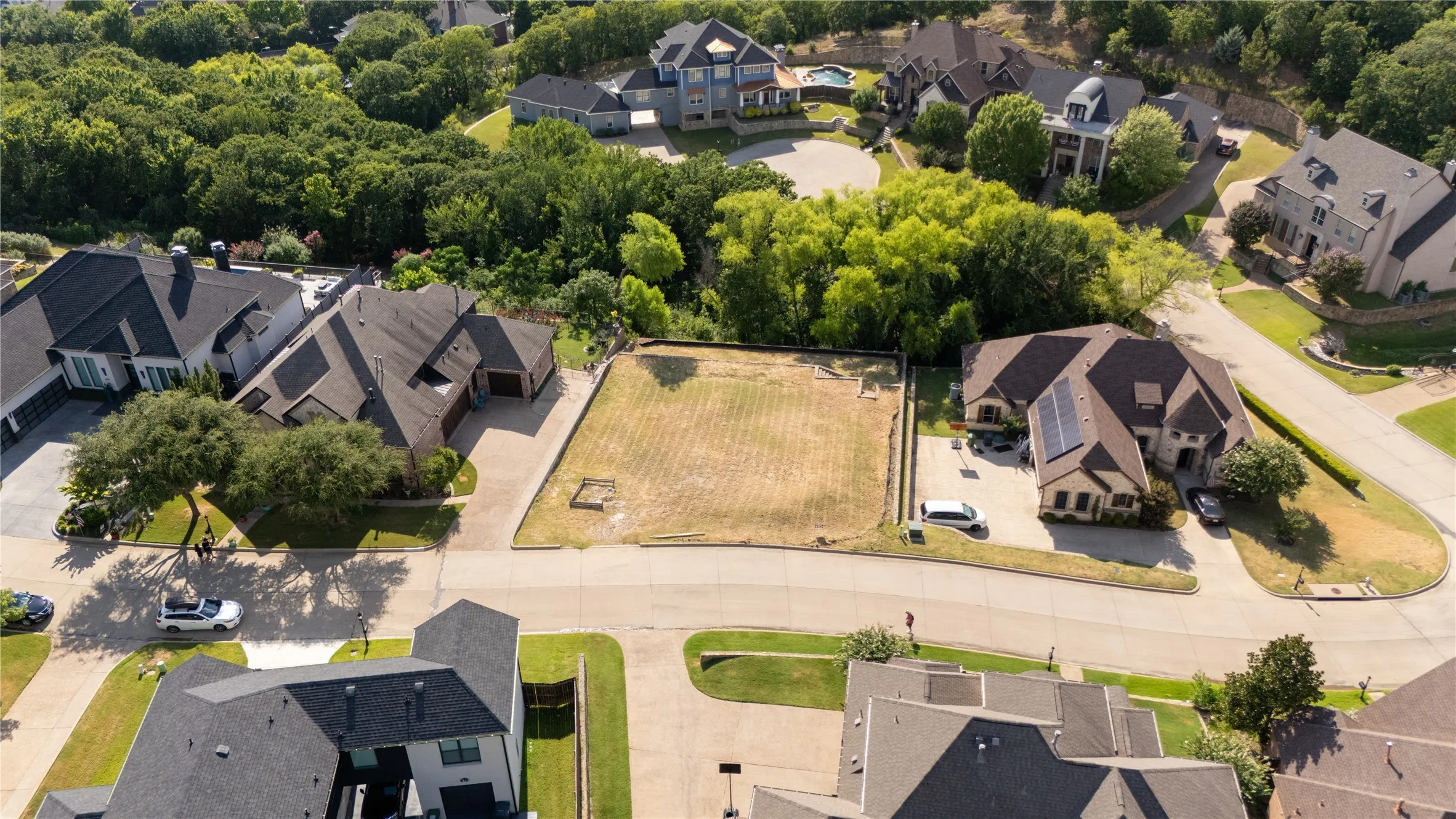 Vacant lot with level terrain, surrounded by established residential properties and mature trees