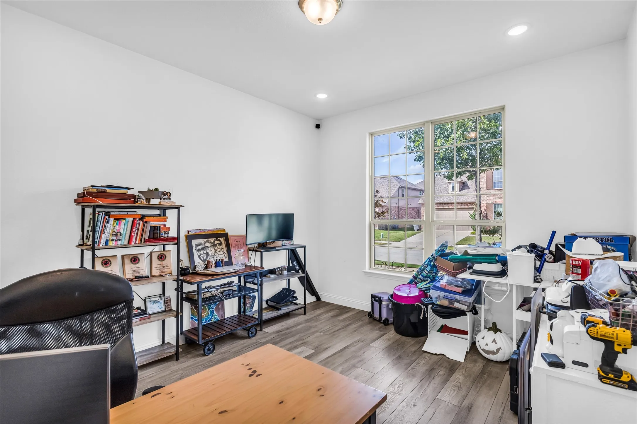 Office with wood finished floors and recessed lighting