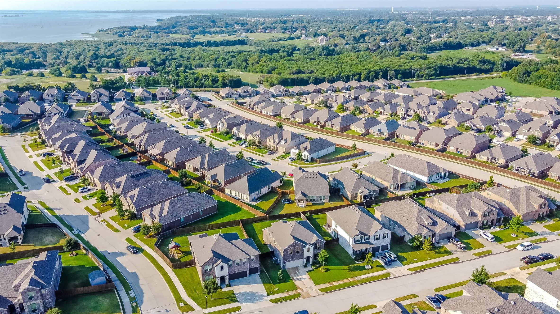 Aerial view of property and surrounding area with a nearby body of water and nearby suburban area