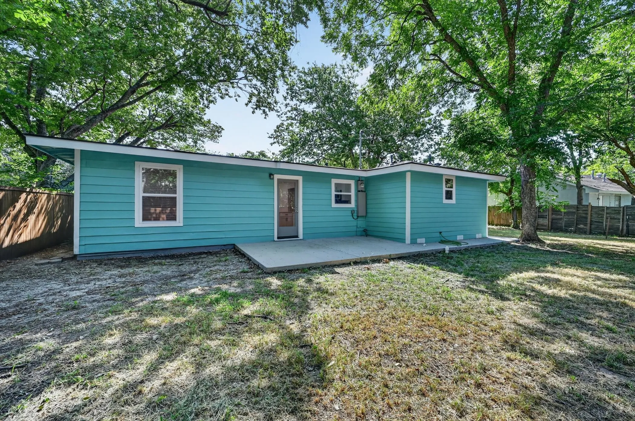 Rear exterior featuring bright turquoise siding and white trim