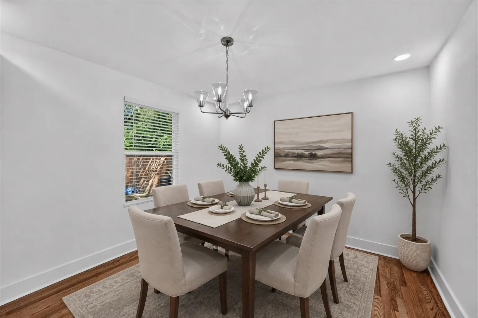 Virtually staged...Bright interior featuring wood-finish flooring, white baseboards, a window with horizontal blinds, and overhead lighting