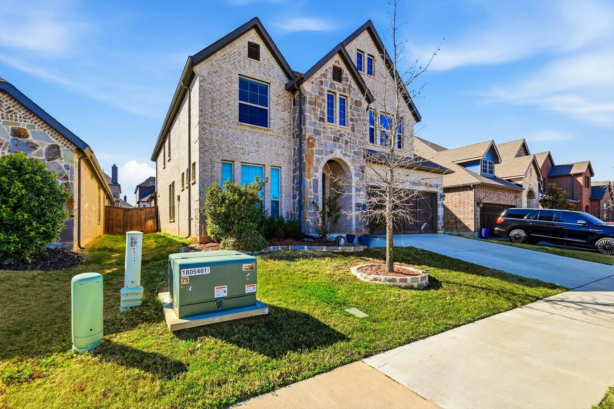 Two-story residence featuring a stone and brick facade