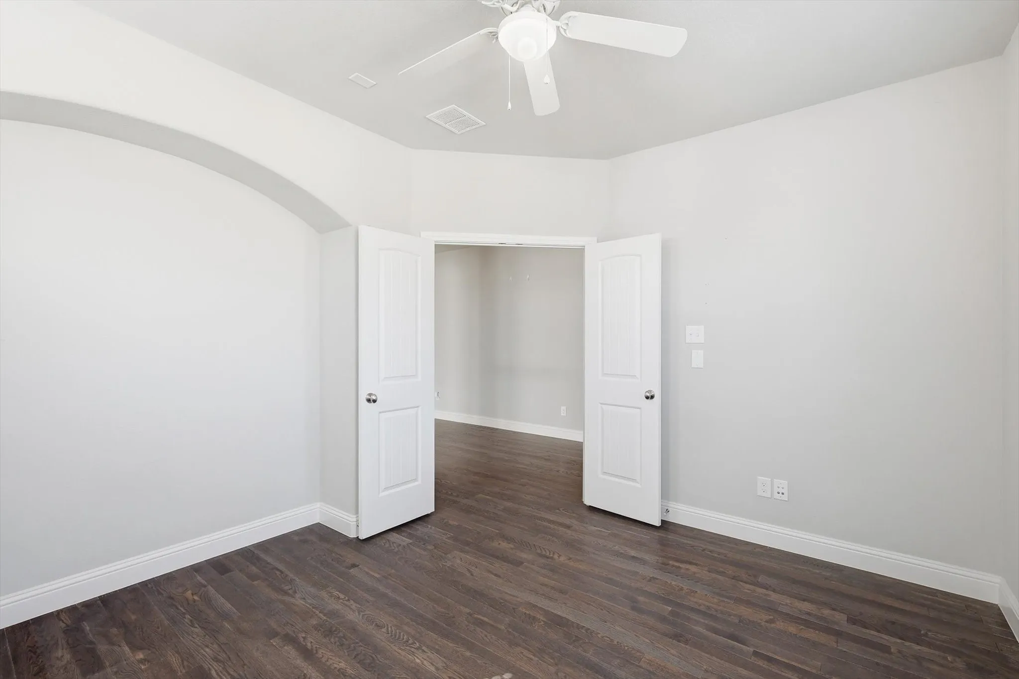 Interior room featuring wood-finish flooring, white baseboards, and light-toned walls