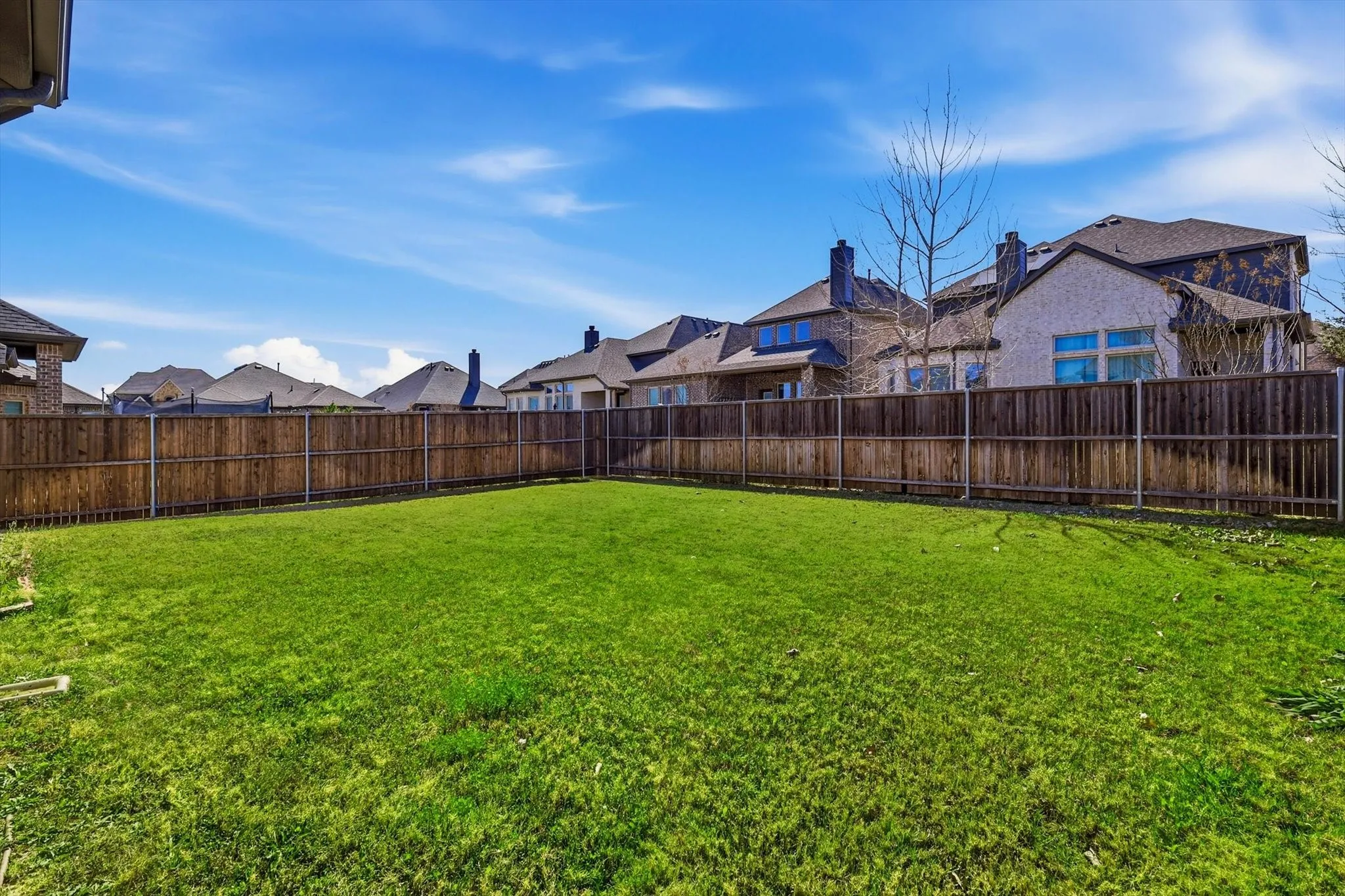 Expansive green lawn with a perimeter wood fence