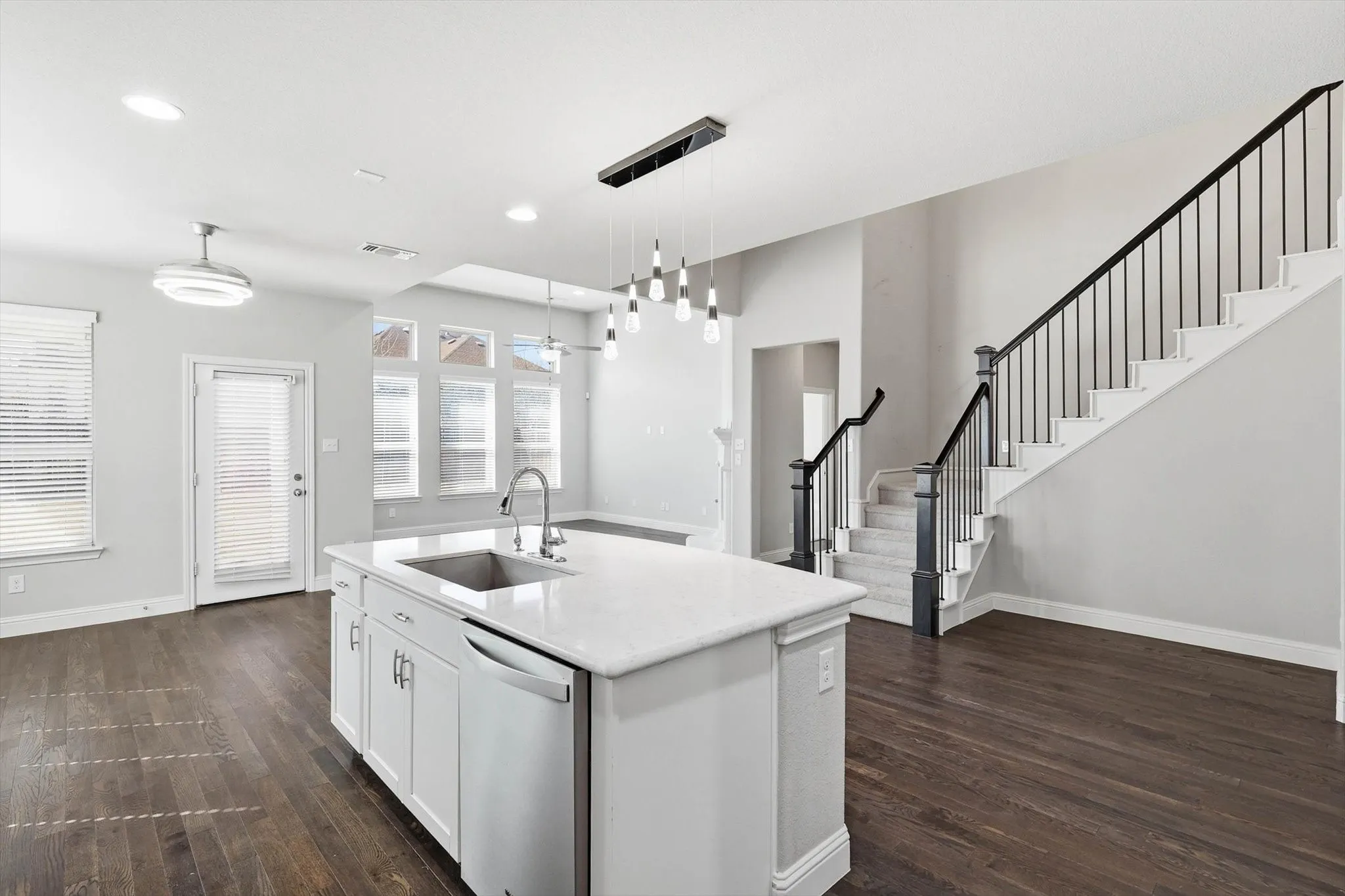 Kitchen island with an undermount sink, a stainless steel dishwasher, and a white countertop