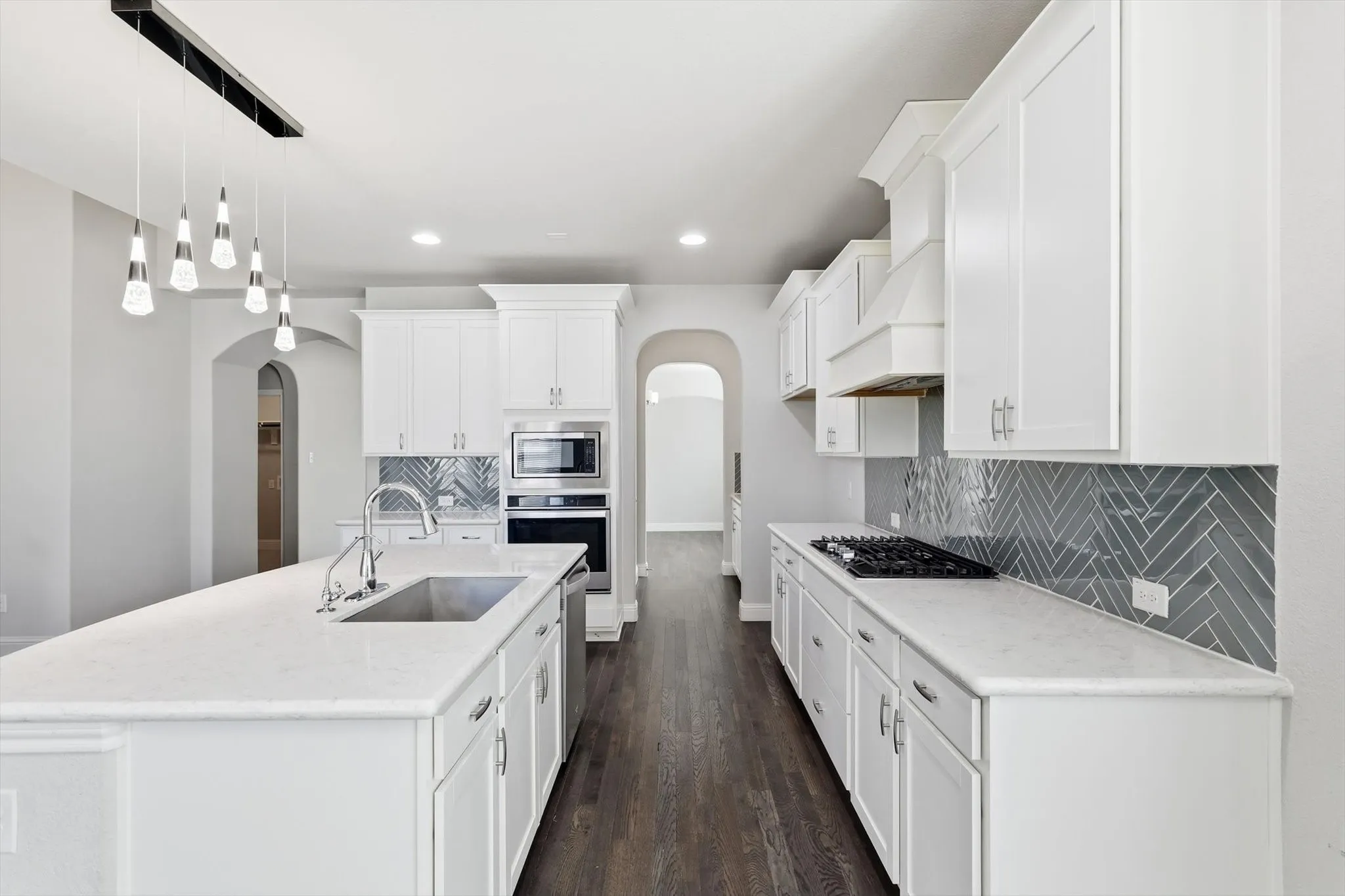 Kitchen featuring white shaker-style cabinetry and a large center island with an undermount sink