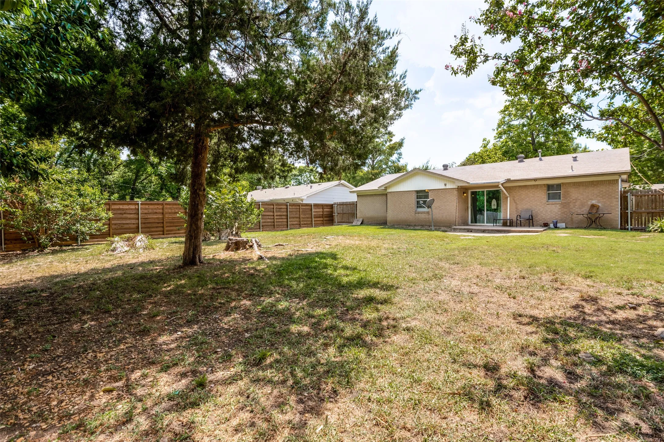Backyard with mature trees and privacy fencing