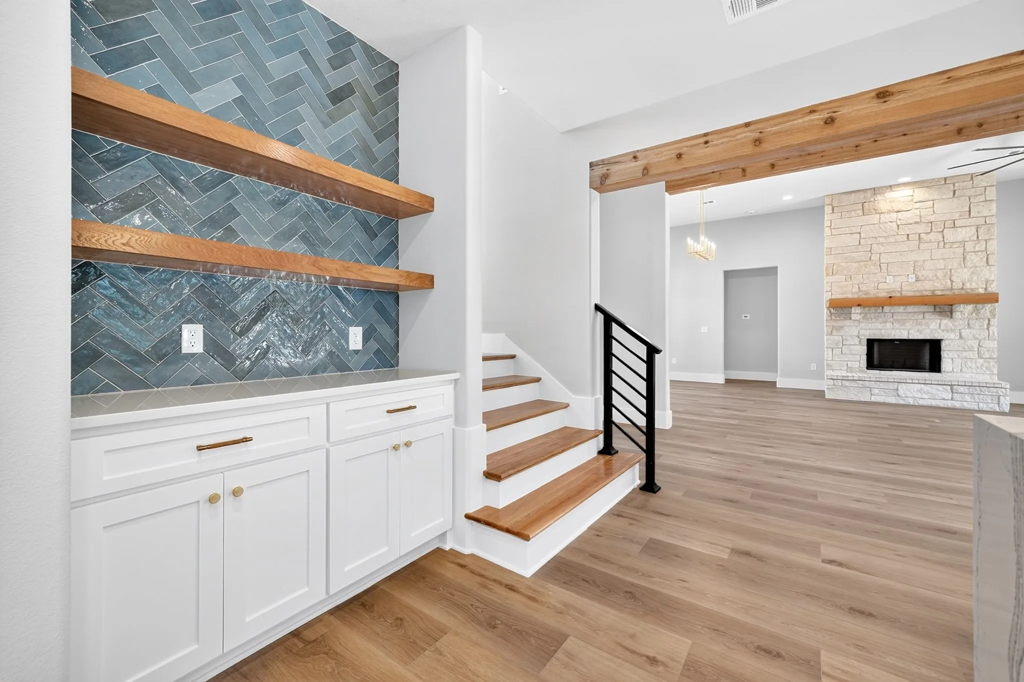 Coffee bar with herringbone tile, built in shelves, and cabinets.
