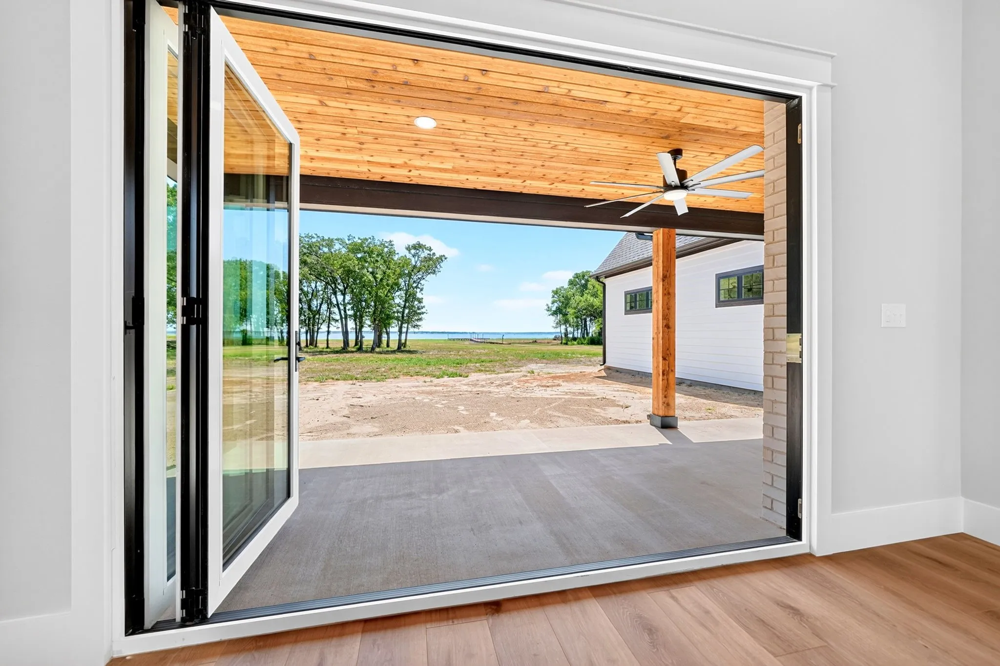 Experience the ultimate indoor-outdoor living!  A multi-panel accordion glass door that fully opens to seamlessly blend the interior space with an expansive covered patio featuring a gorgeous cedar tongue-and -groove ceiling and beautiful lake views.