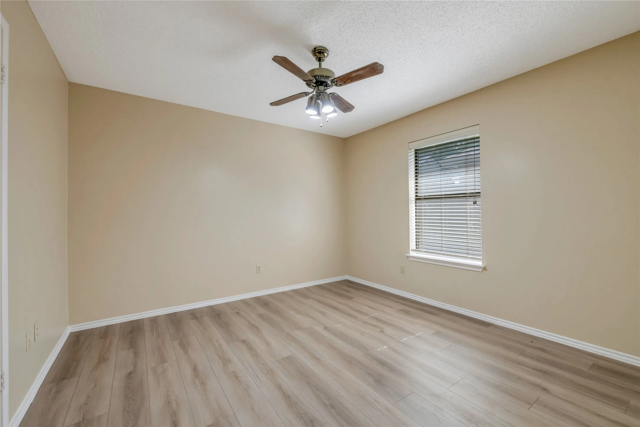 Third Spacious Bedroom featuring Wood-look luxury vinyl plank flooring, neutral-toned walls, and a ceiling fan with integrated lighting