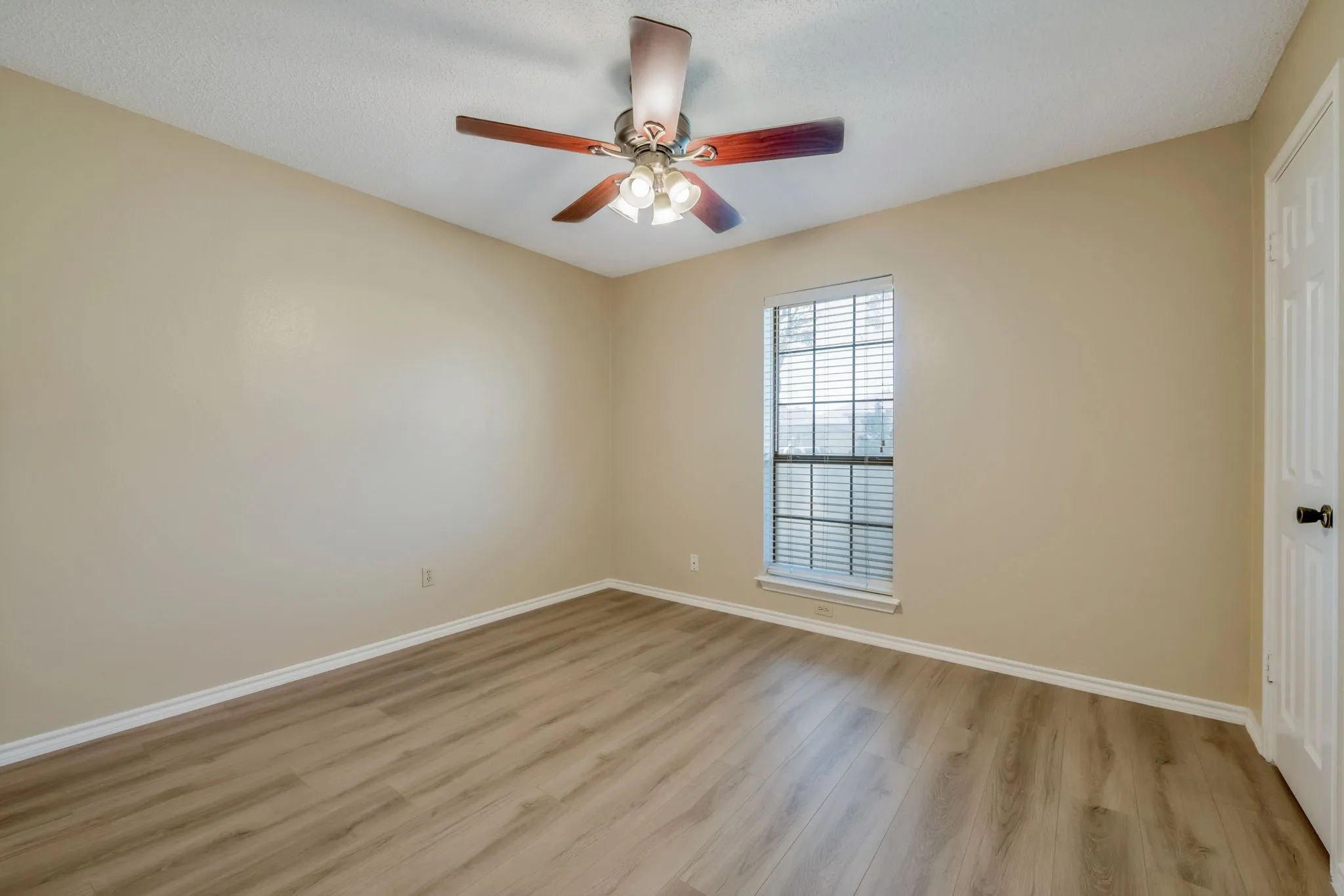 
Third Spacious Bedroom featuring Wood-look luxury vinyl plank flooring, neutral wall paint, and a white ceiling with a textured finish