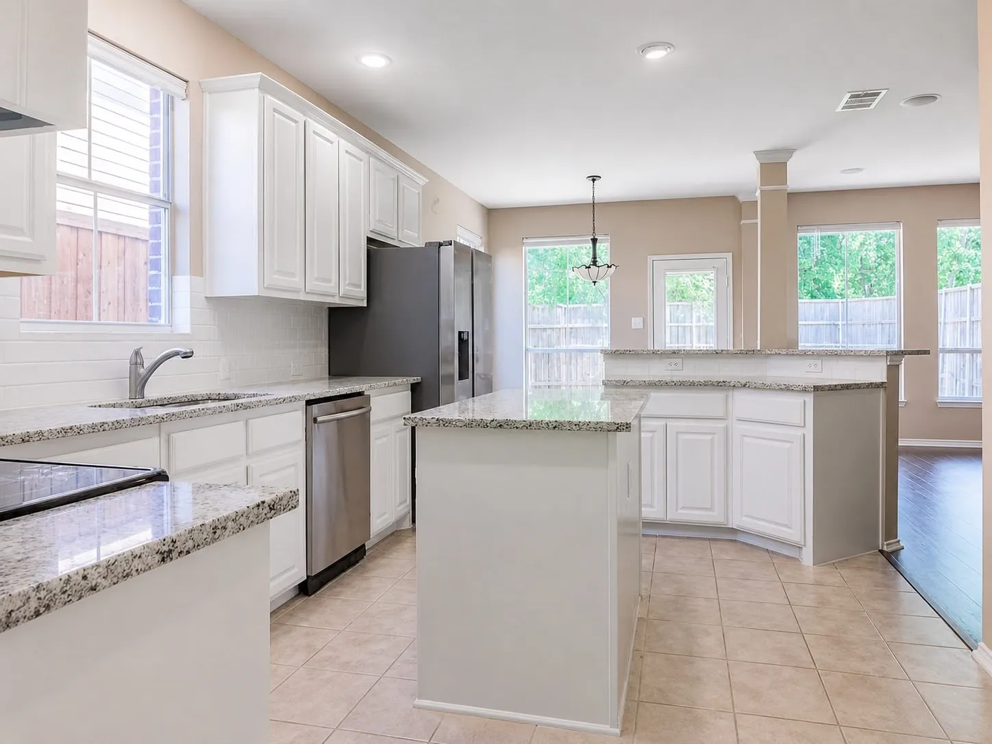 Kitchen featuring granite countertops, white cabinetry, stainless steel appliances, tile flooring, and a white subway tile backsplash