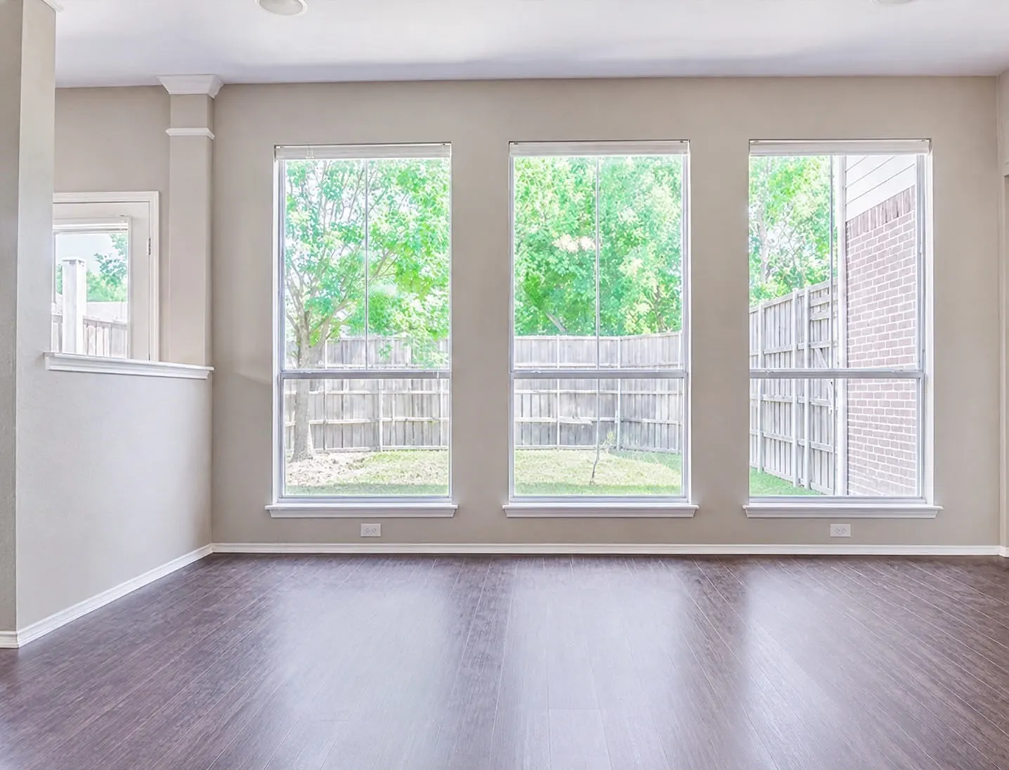 Interior space featuring wood-finish flooring and a series of three vertical windows