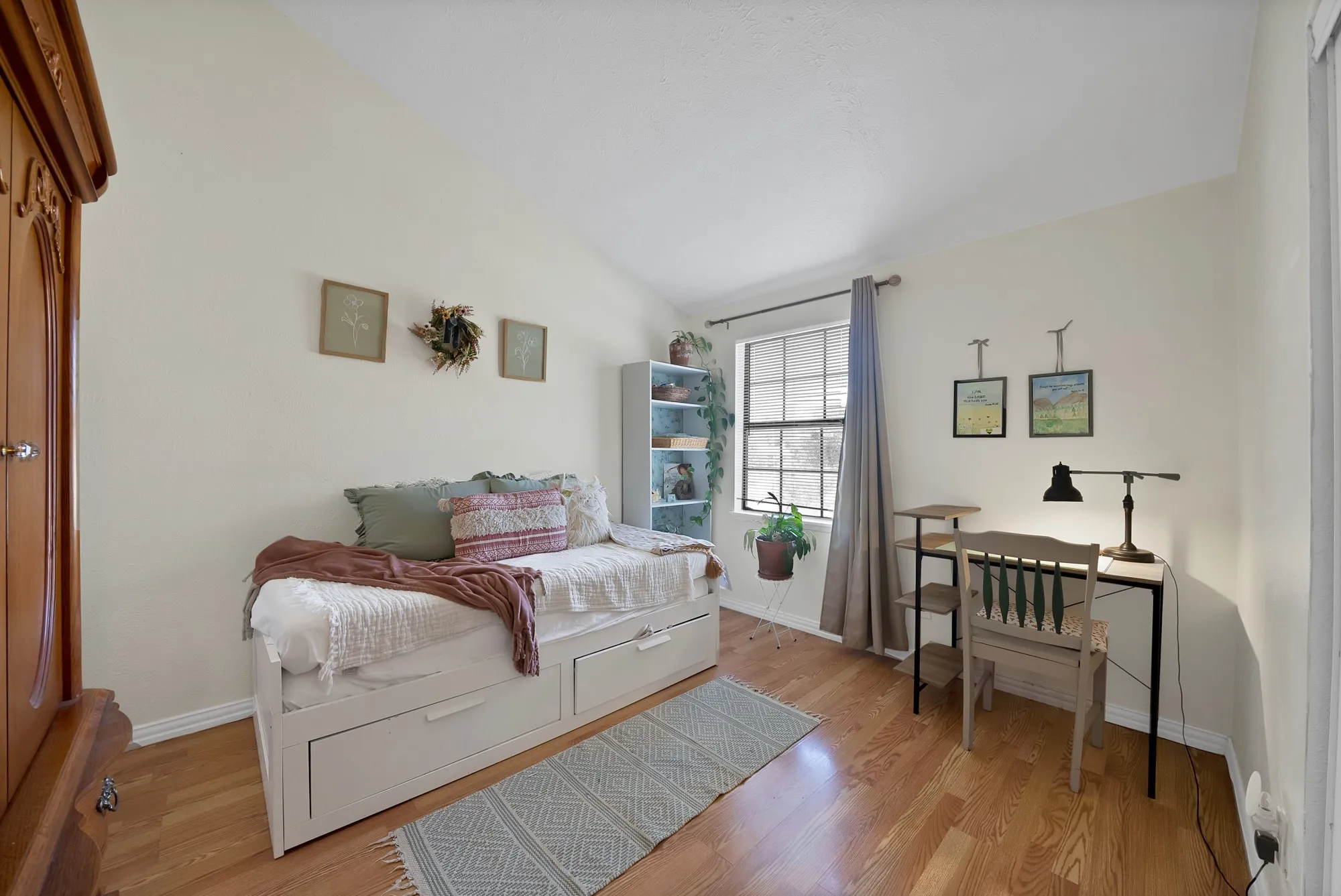 Room featuring wood-finish flooring, a window with blinds, and light-toned walls