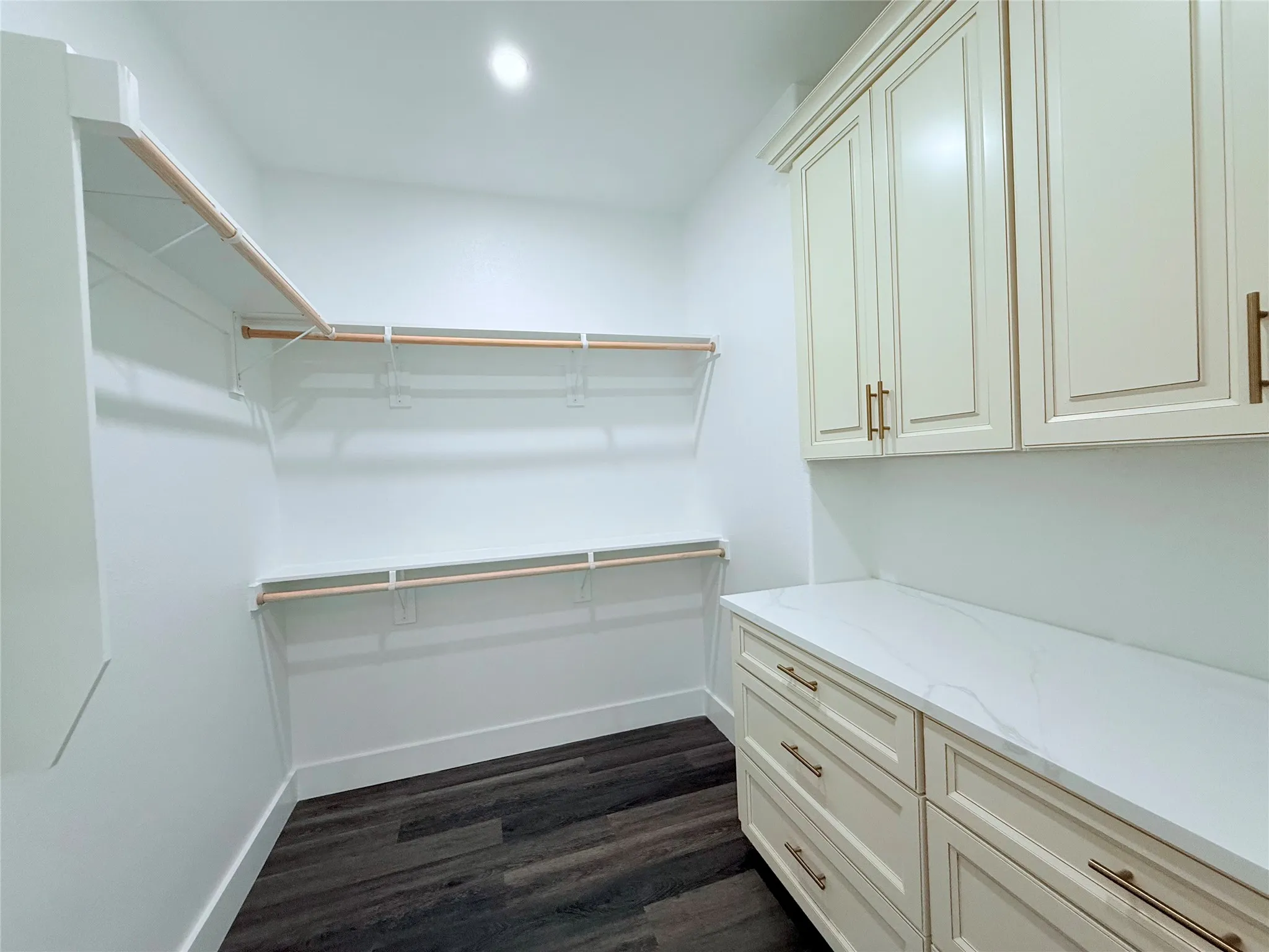 primary bedroom walk in closet with built in drawers and cabinets
