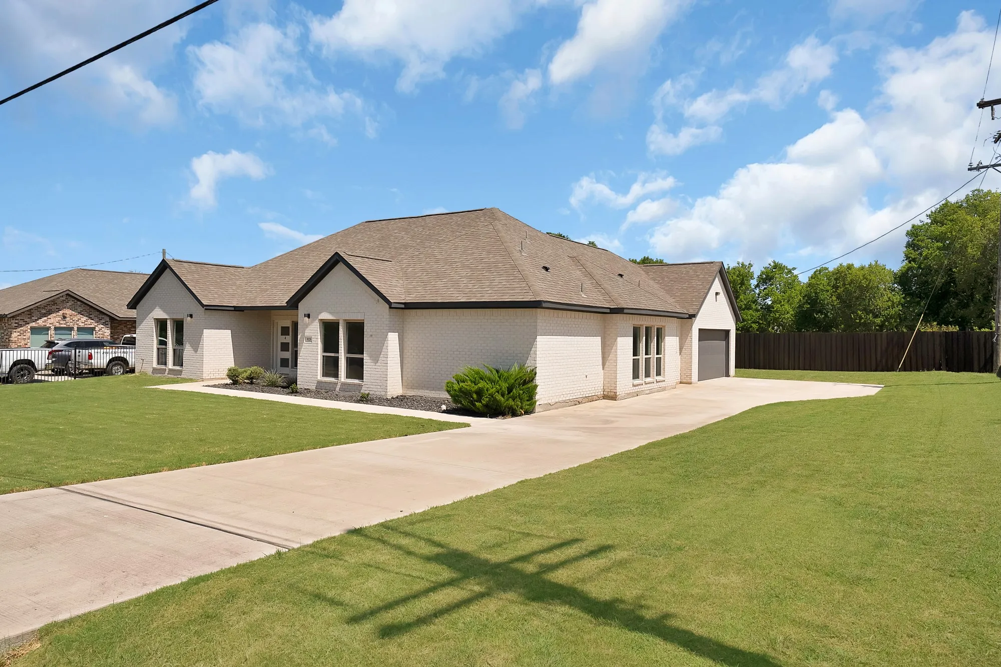 Cream brick exterior with dark trim and a gabled roofline