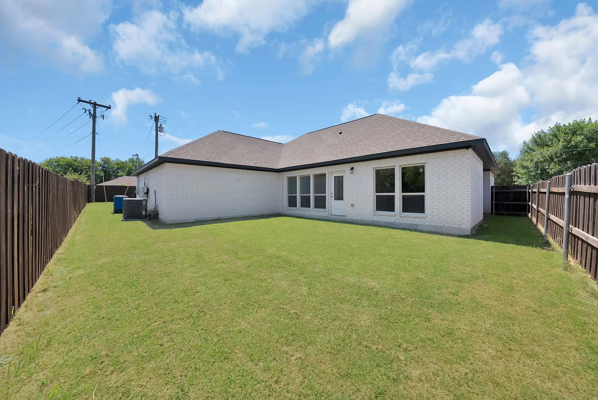 Expansive fenced yard with a manicured lawn