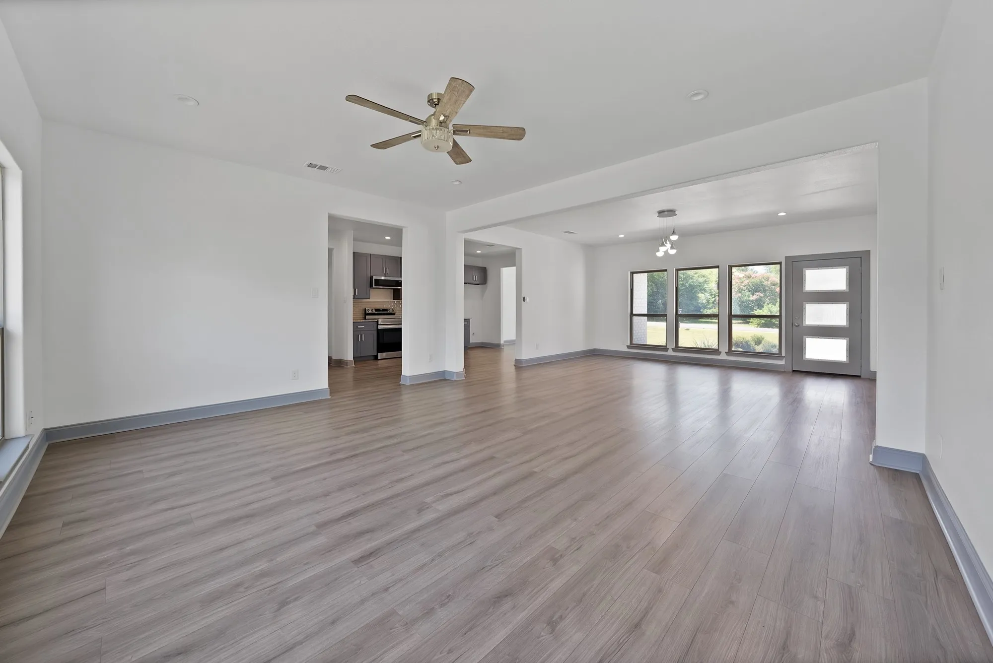 Spacious interior featuring wood-finish flooring, recessed lighting, and a ceiling fan