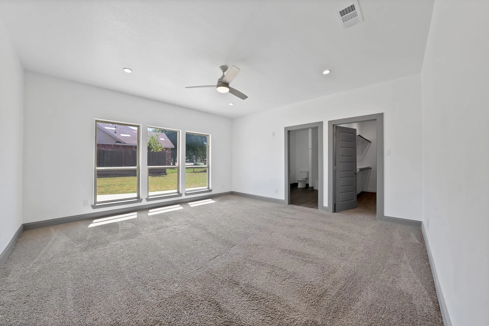 Spacious room featuring gray carpeting and a neutral color palette