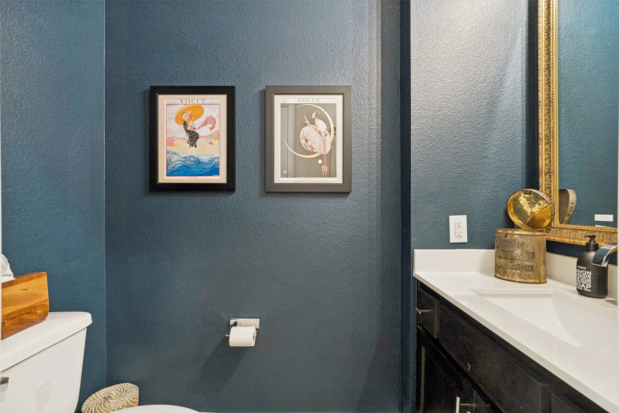 Bathroom featuring a single-basin vanity with a white countertop and dark cabinetry