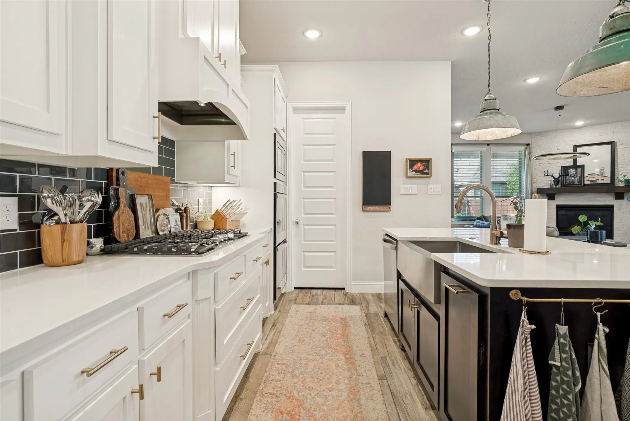 Contemporary kitchen featuring white cabinetry, dark subway tile backsplash, and light countertops