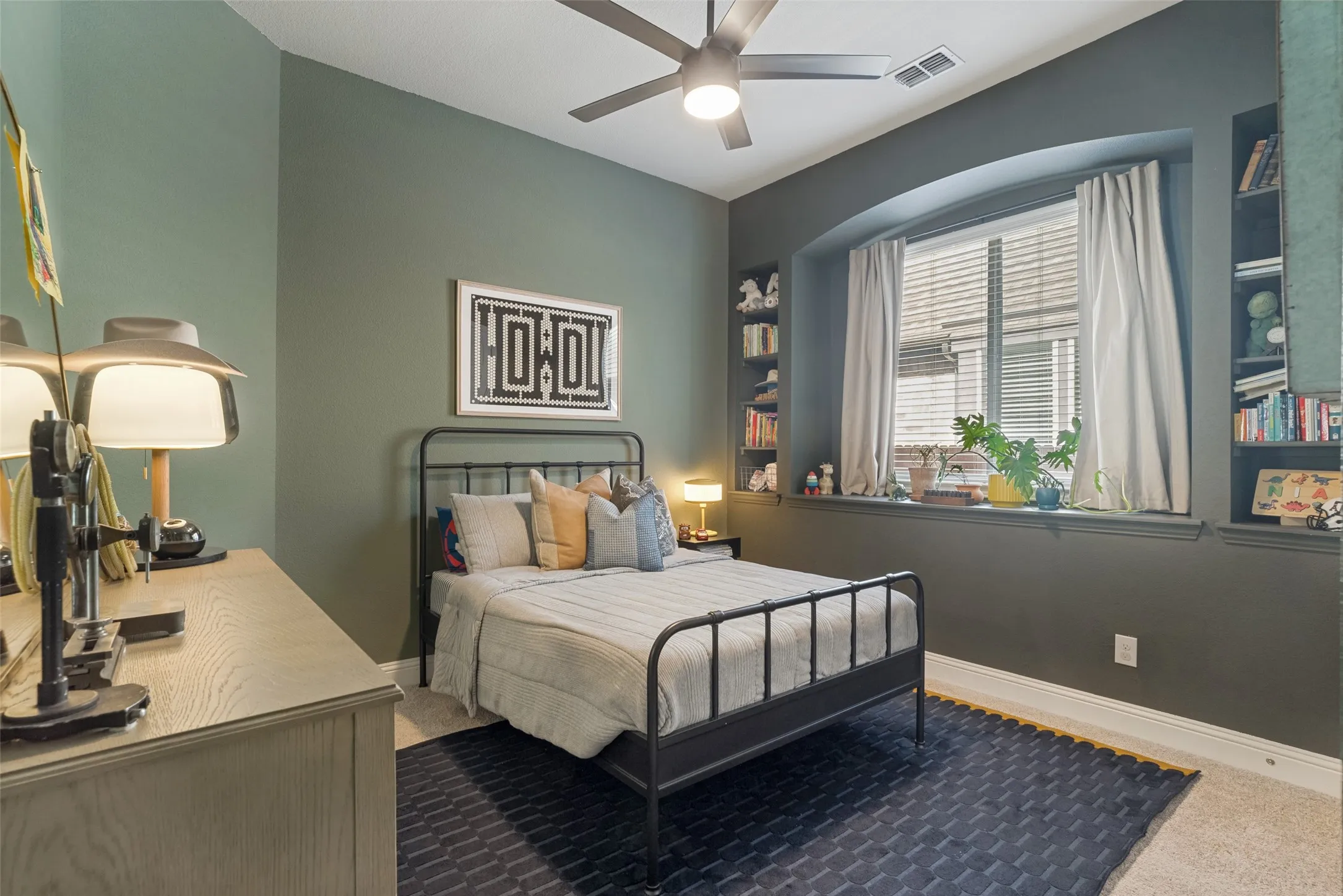 Carpeted room with a ceiling fan