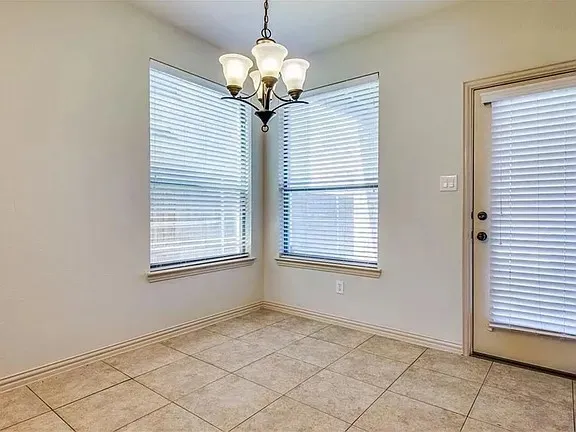 Neutral-toned ceramic tile flooring complemented by a classic chandelier with frosted glass shades