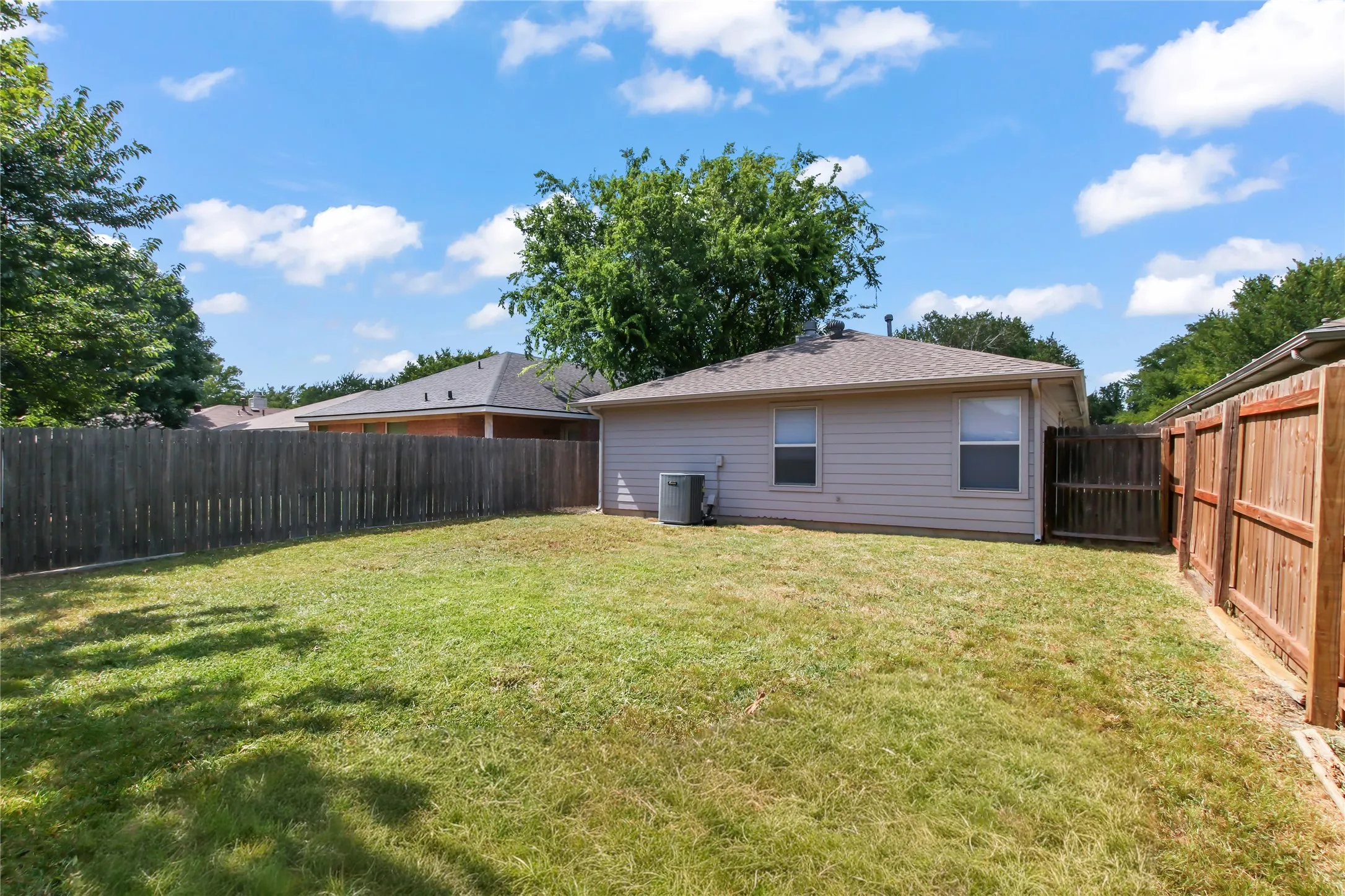 Rear exterior with a spacious grass lawn