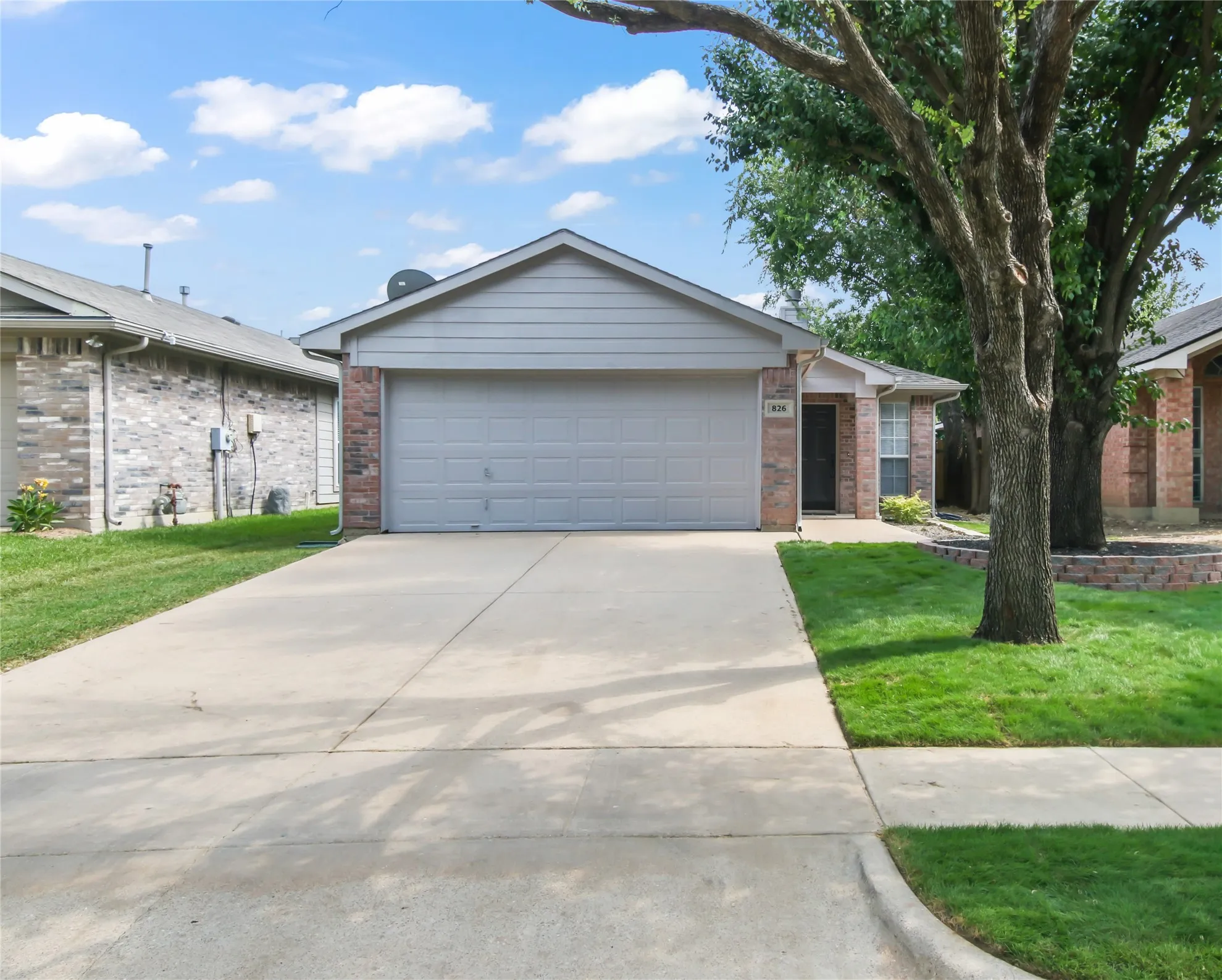 Single-story residence featuring a brick and siding exterior, an attached two-car garage, and a concrete driveway