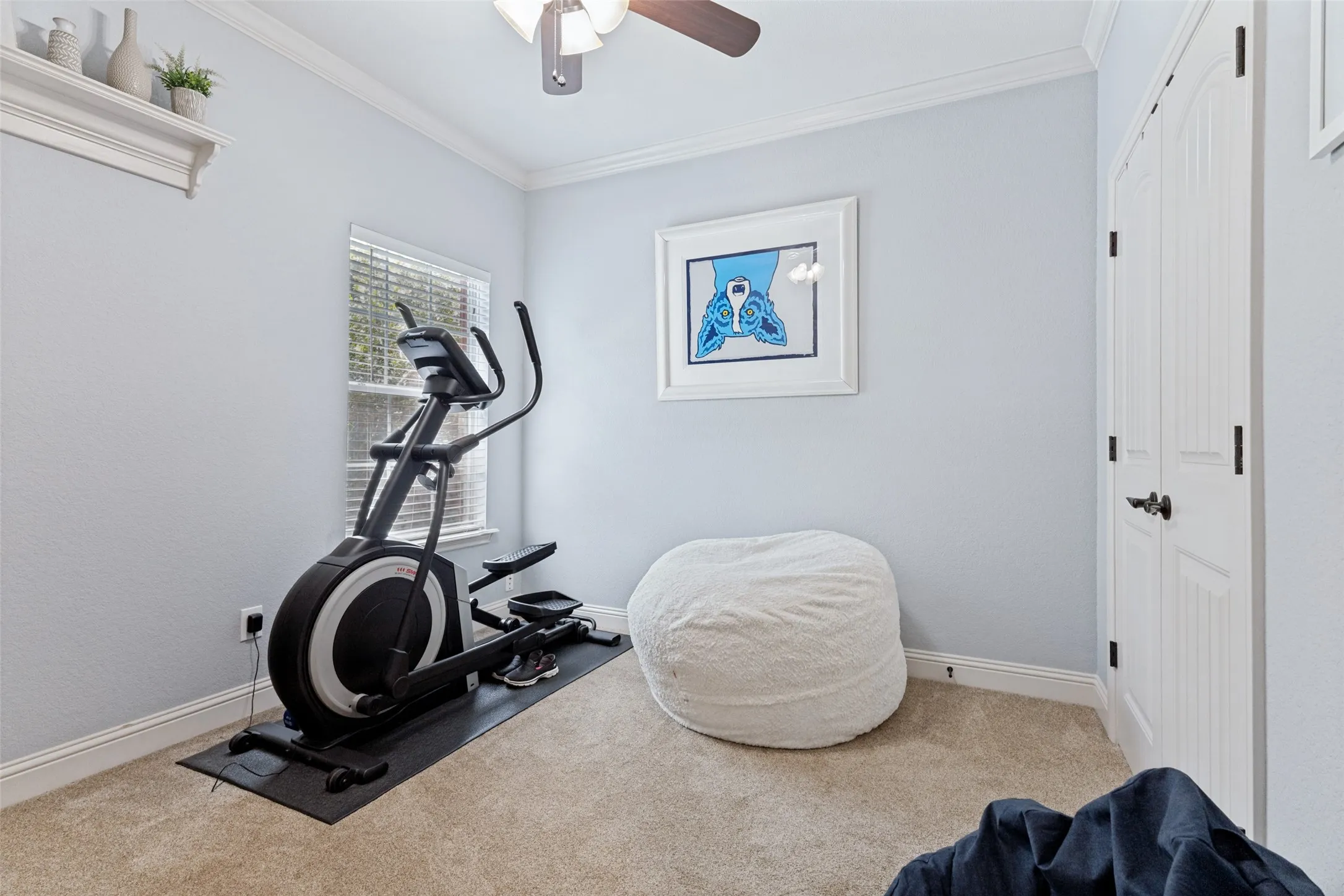 Light gray walls complementing neutral carpeting in this 3rd bedroom with a double door closet