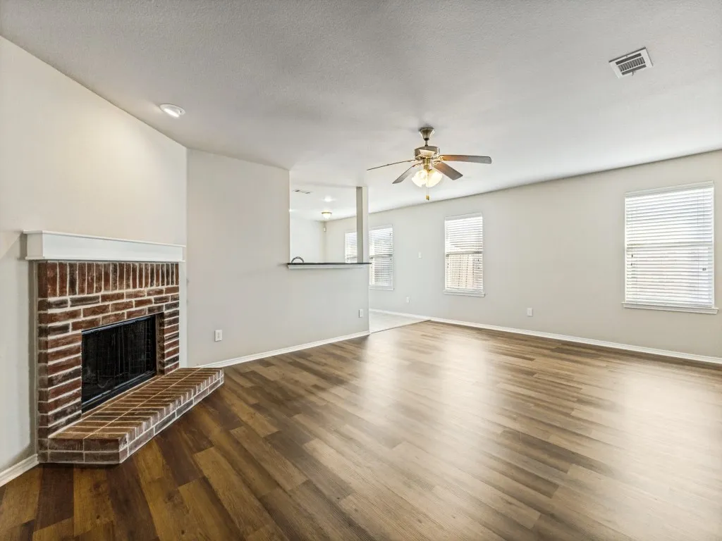 Living area featuring wood-finish flooring, a brick fireplace with a white mantel, recessed lighting, and a ceiling fan