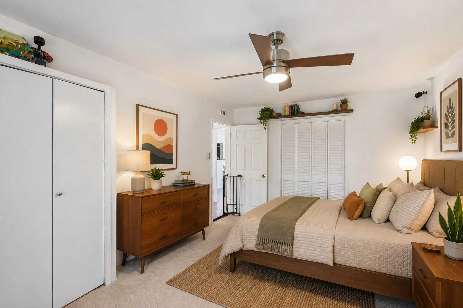 Bedroom featuring light neutral carpeting, a built-in ceiling fan with integrated lighting, a spacious bi-fold closet with louvered doors, and a second closet with white panel doors