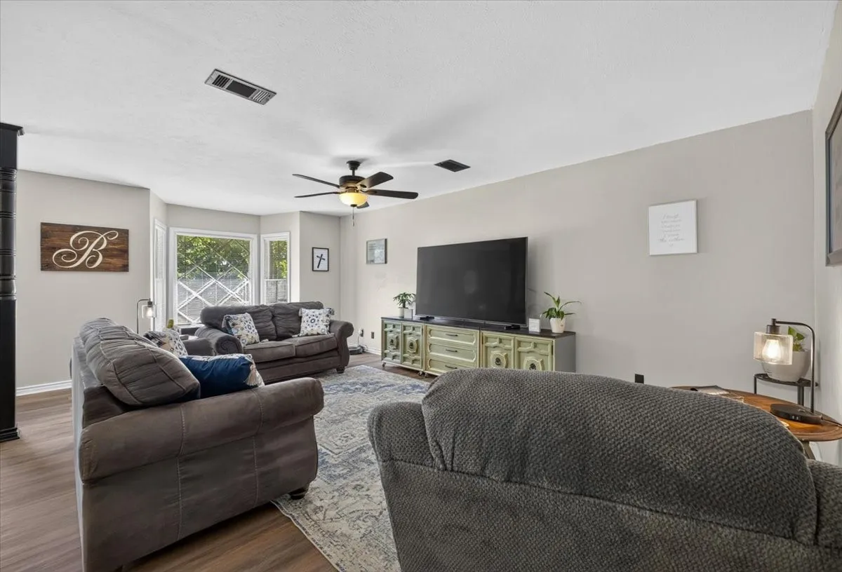 Living area with updated flooring, natural light, and flexible furniture layout