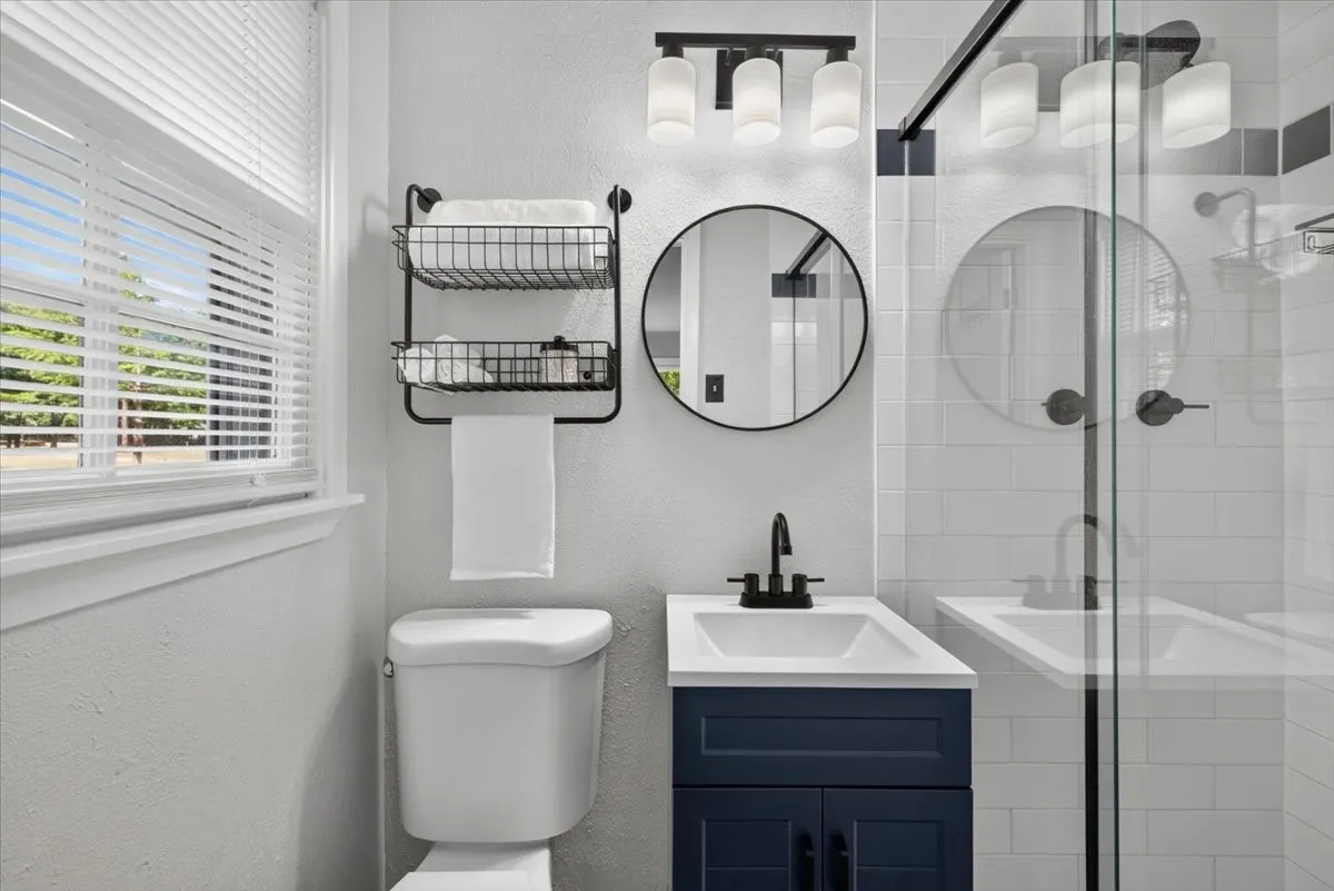 Primary bathroom with walk-in shower, updated fixtures, and natural light