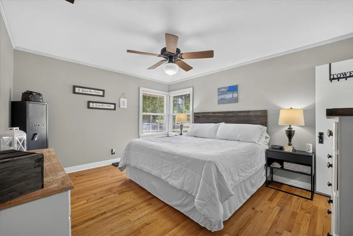 Primary bedroom with original hardwood flooring and natural light