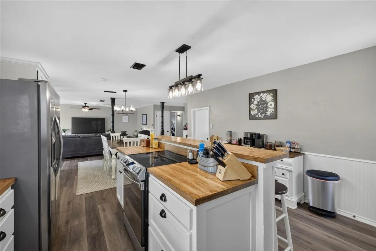 Kitchen view toward dining and living areas with updated flooring throughout main spaces