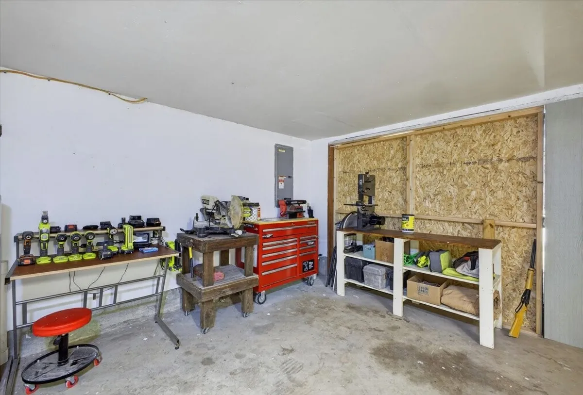 Garage workshop area with storage, workbench space, and exterior access
