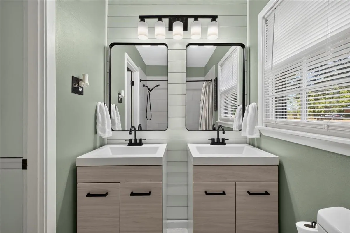 Hall bathroom with dual vanities, updated lighting, and refreshed finishes