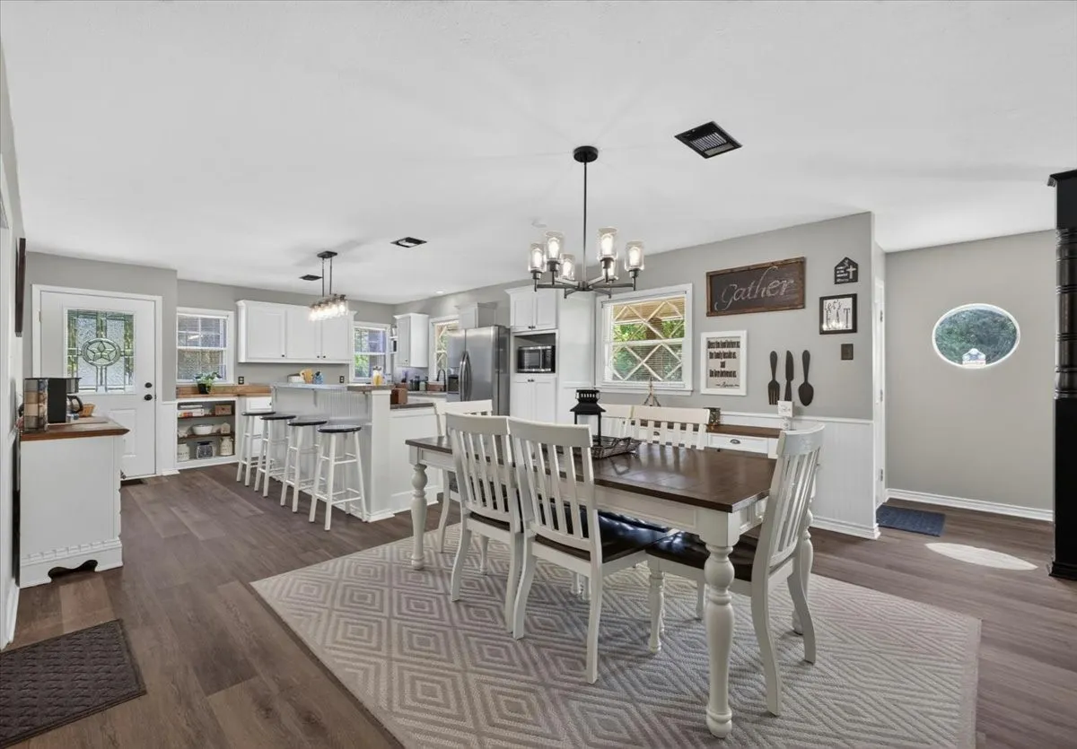 Open dining and kitchen area with updated flooring and natural light