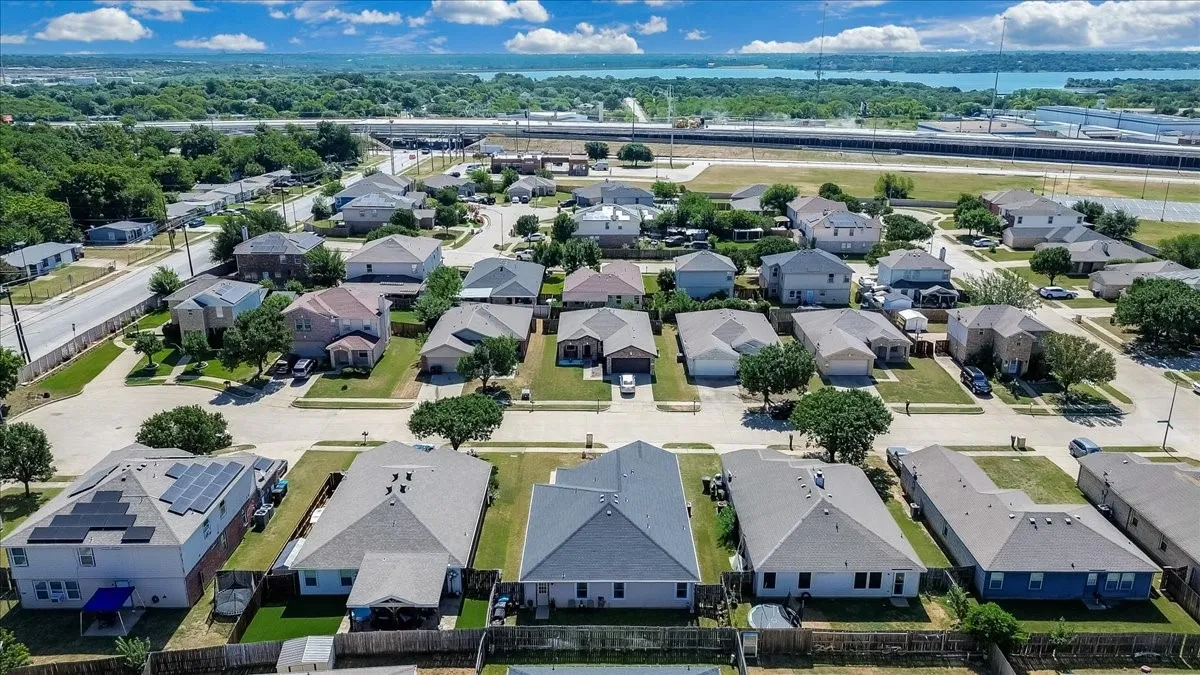 Residential neighborhood with established homes and mature trees, featuring varied architectural styles and rooflines, some with solar panel installations