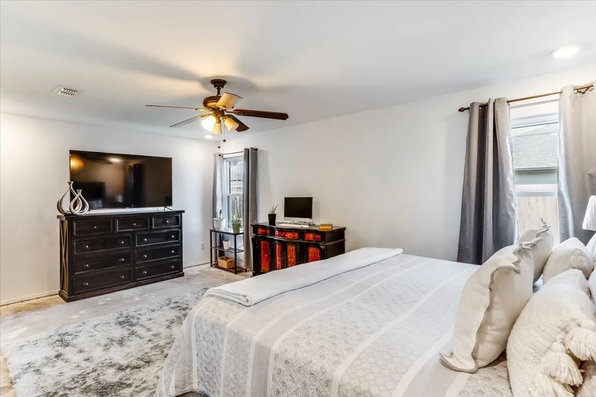 Spacious room featuring light-colored walls, a ceiling fan with integrated lighting, and recessed lighting fixtures