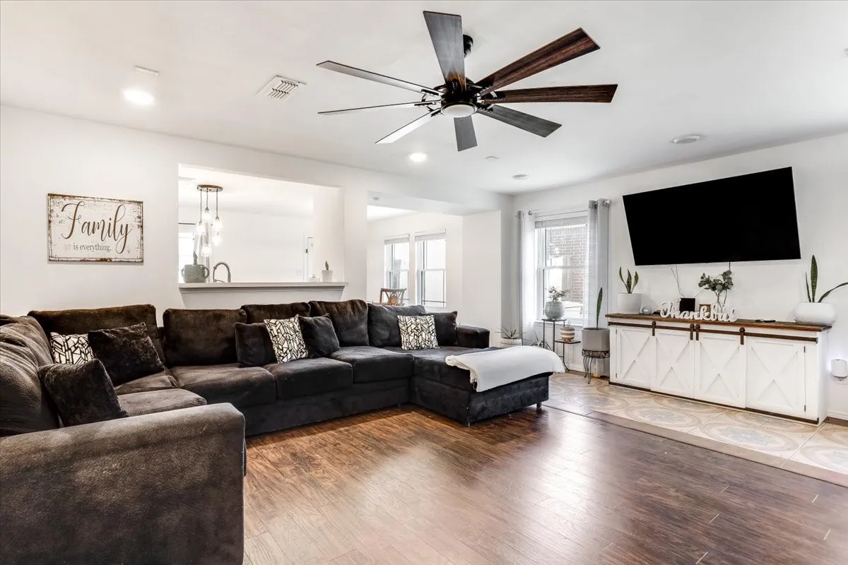 Open-concept living area featuring wood-finish flooring, recessed lighting, and a contemporary ceiling fan
