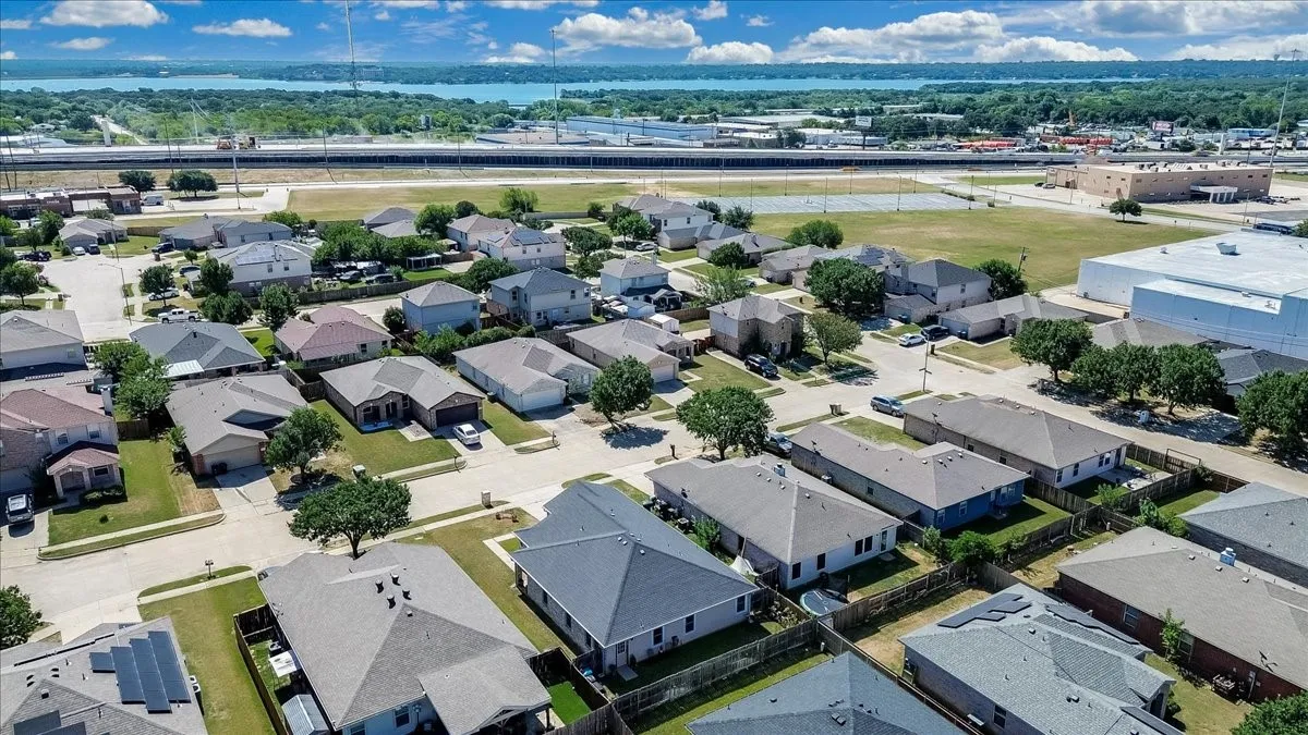 Suburban neighborhood featuring a variety of single-family homes with gray shingle roofs and manicured lawns
